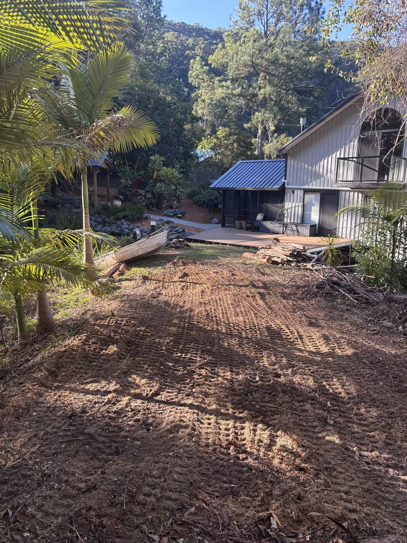 Ground levelled and cleared of stumps beside a home, ready for turf or new planting